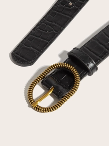 Detailed macro view of black crocodile pattern belt with vintage gold textured buckle
