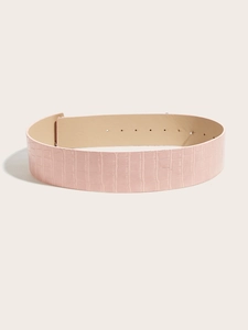 Detail shot of pink crocodile pattern leather belt with smooth interior and metal holes