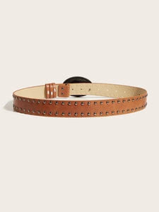 Detail view of brown studded belt with round black buckle and dual metal rivets