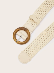 Detail of woven straw belt with a natural wooden buckle and cream faux leather accents