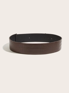 Detailed close-up of dark brown crocodile texture pattern on wide faux leather belt
