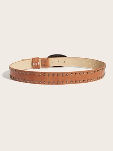 Détail de ceinture en cuir marron vintage avec clous argentés et boucle en métal gravé