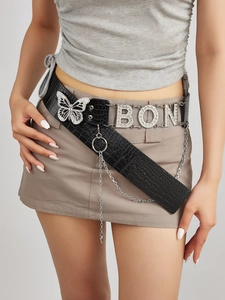 Detail of black faux leather belt featuring silver butterfly buckle and rhinestone BON letters