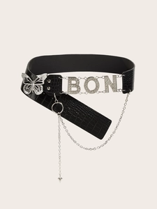Detail of black faux leather belt with crocodile pattern, butterfly buckle and BON rhinestones
