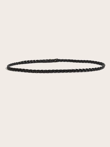Detail shot of black woven belt for women with elegant metallic buckle on beige background