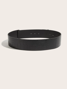 Macro detail of black crocodile embossed leather belt showing fine texture and pin holes