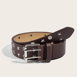 Dettaglio cintura in pelle marrone con borchie a stella argentate e occhielli su fondo beige