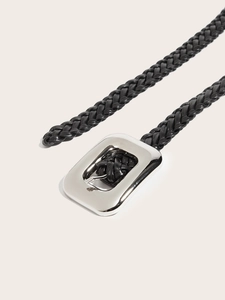 Détail d'une ceinture tressée en cuir noir avec boucle métallique carrée argentée