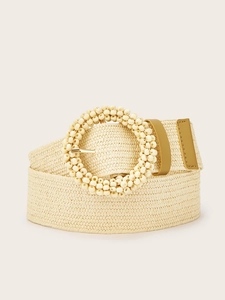 Detail of beige braided waist belt with round beaded buckle and golden metal accents
