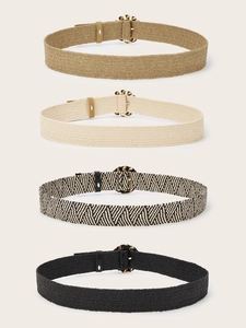 Detail of four woven elastic belts in various colors with decorative round buckles