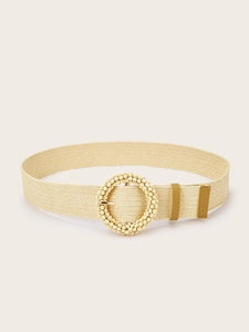 Macro detail of beige woven belt featuring a round buckle decorated with small beads
