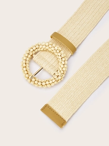 Detail of bohemian woven belt featuring a beaded round buckle and cream braided texture