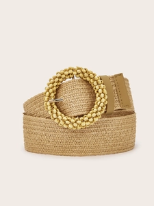 Macro shot of a woven bohemian belt with a round buckle decorated in wooden beads