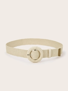 Detail of a beige woven elastic belt featuring a large round straw-wrapped buckle