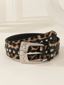 Detail of leopard print punk belt with silver cone studs and vintage engraved metal buckle