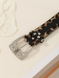 Detail of leopard print belt with vintage engraved silver buckle and metal studs