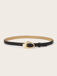 Détail d'une ceinture fine en cuir noir pour femme avec une boucle ovale en métal doré
