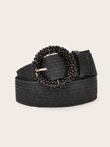 Detail of black woven belt with beaded round buckle and metallic gold pin closure