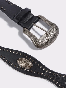 Dettaglio della fibbia floreale stile western e borchie d'argento su pelle nera