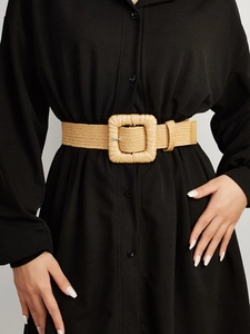 Detail of khaki woven belt with square buckle on black shirt dress for women