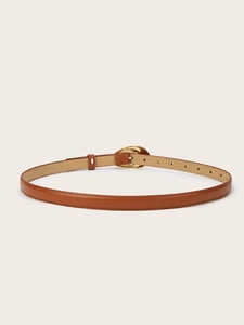 Gros plan d'une ceinture en cuir camel avec une boucle en métal doré poli en forme de cœur