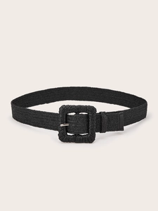 Close-up of black woven belt with raffia texture and matching square buckle detail