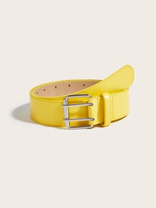 Detail view of yellow leather belt with silver square double buckle on cream background