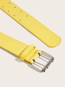 Detail of bright yellow leather belt featuring double-row holes and silver metal buckle
