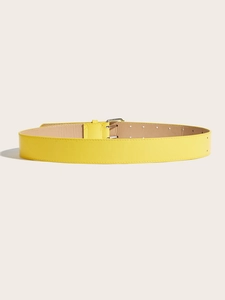 Detail of yellow leather belt with fine grain texture and silver metal buckle
