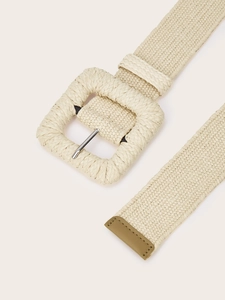Detail shot of a woven cream belt featuring a textured square buckle and leather tip