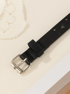 Detail shot of black thin waist belt with silver buckle and star-shaped cutouts