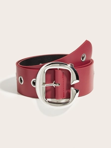 Dettaglio cintura punk in pelle rossa con grande fibbia a C in metallo argento e occhielli