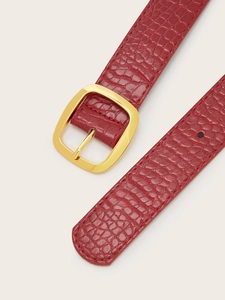 Close-up of deep red faux leather belt with crocodile pattern and gold buckle