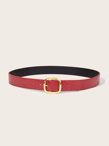 Detail shot of a red faux crocodile leather belt with a polished gold square buckle