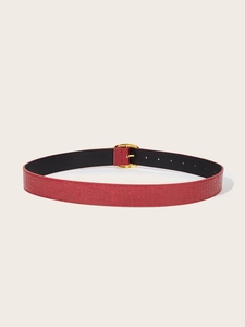 Detail of red crocodile texture leather belt with gold pin buckle for jeans