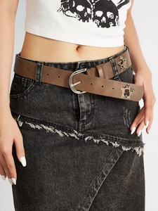 Close-up of brown leather belt with leopard star studs and silver D-ring buckle