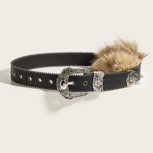 Détail d'une ceinture en cuir noir gaufré avec boucle argentée ornée et garniture en fourrure