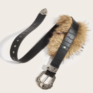 Détail d'une ceinture bohème en similicuir noir avec boucle gravée et rivets métalliques