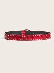 Detailed macro view of red crocodile-embossed leather belt with silver punk rivets