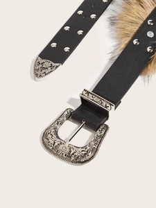 Detail der verzierten Silberschnalle im Western-Stil und Webpelzbesatz am Ledergürtel