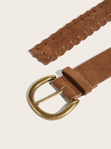 Dettaglio di una cintura in camoscio marrone scuro con fibbia in ottone e trama intrecciata