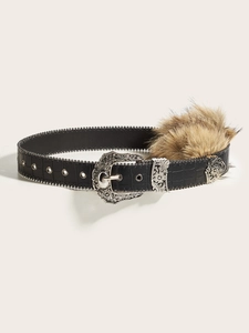 Détail de la ceinture en cuir gaufré avec pompon en fausse fourrure et boucle argentée ciselée