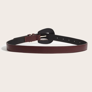 Vintage burgundy leather belt for women with elegant horseshoe metal buckle on cream background