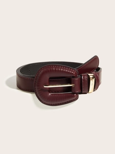 Close-up of vintage burgundy leather belt with a large gold buckle and metal loop