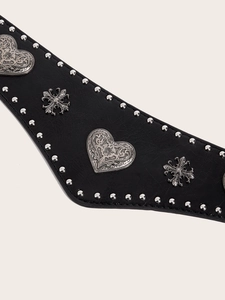 Macro detail of black leather belt featuring silver rivets and gothic heart cross accents