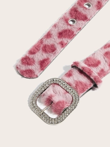 Detail eines rosa Leoparden-Plüschgürtels mit funkelnder Strass-Schnalle und Metallösen
