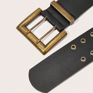 Macro shot of the dual-prong bronze buckle and double eyelet detail on black leather belt