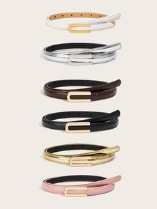 Close-up of thin women's belts in six colors featuring crocodile texture and U-shaped buckles