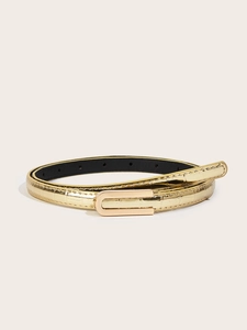 Detail view of gold crocodile embossed leather belt with a minimalist U-shaped metal buckle