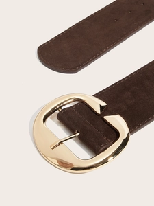 Détail macro de la ceinture en daim marron foncé avec boucle ovale en métal doré